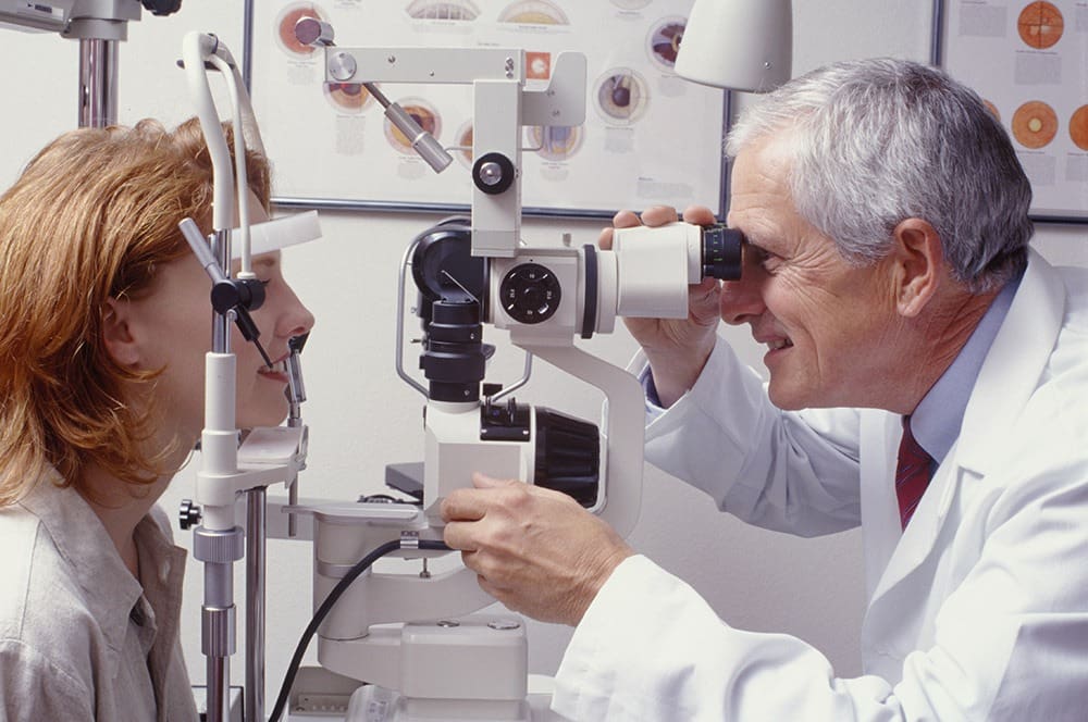 A woman getting an eye exam from a doctor