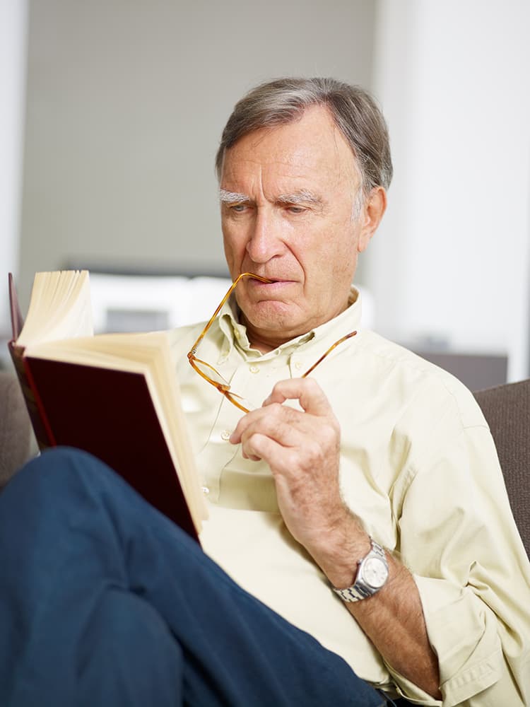 A man with glasses reading a book