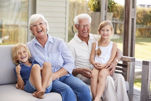 Grandparents With Grandchildren Relaxing On Deck At Home
