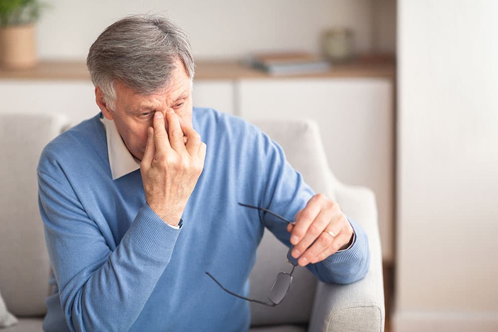 Senior man with pain in his eyes