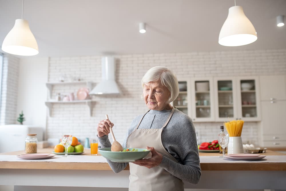 A senior woman cooking in a kitchen