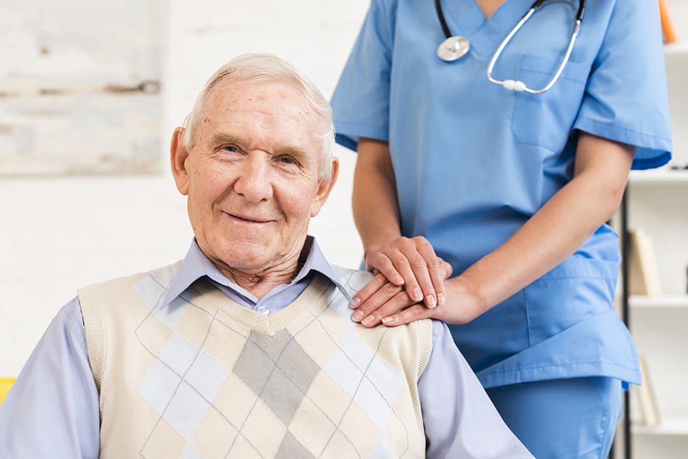 caregiver holding senior man's shoulder