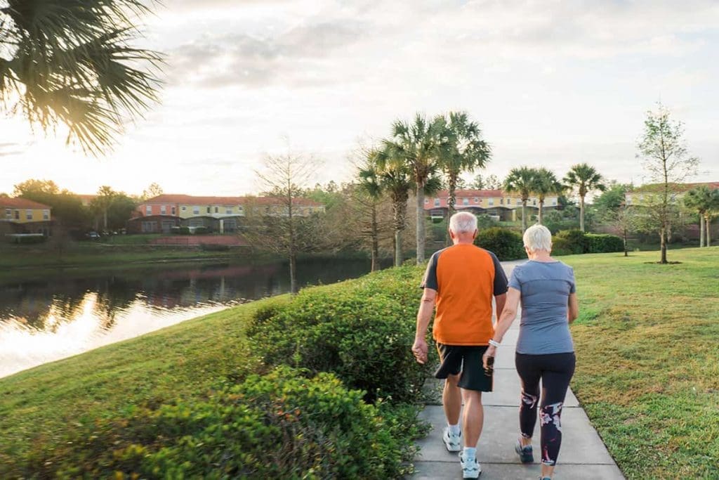 two older couple walking near a lake