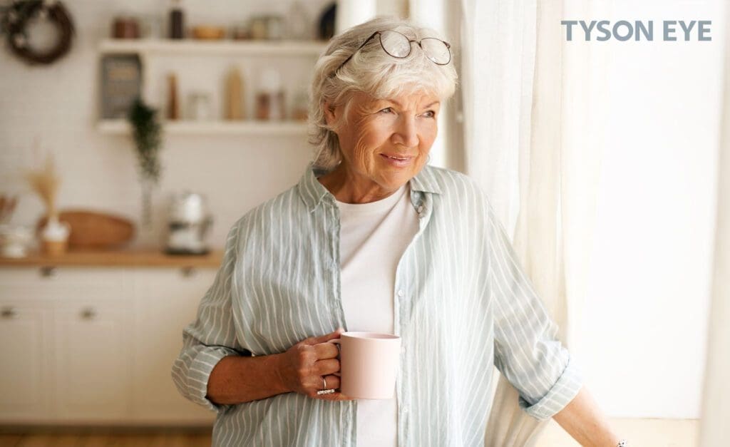 a person drinking coffee smiling with the signs of having astigmatism