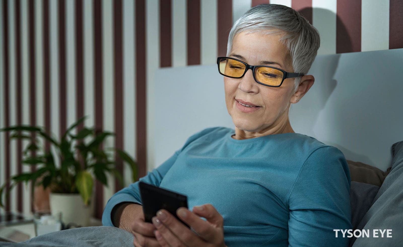 The Benefits of Blue Light Glasses. Woman wearing glasses looking at a screen.