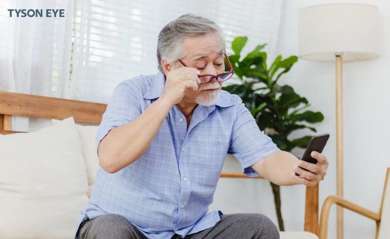 Understanding Vision Correction Options man looking at a smartphone with glasses